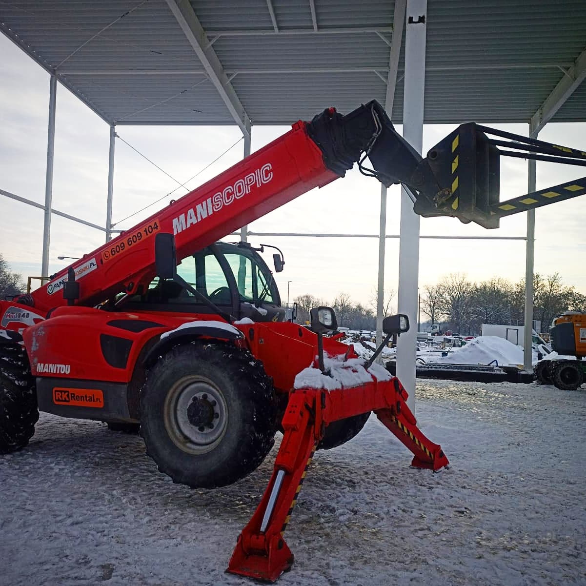 Ładowarka teleskopowa Manitou MT 1840 Maniscopic z koszem roboczym na podporach przy budowie hali produkcyjnej — RK Rental