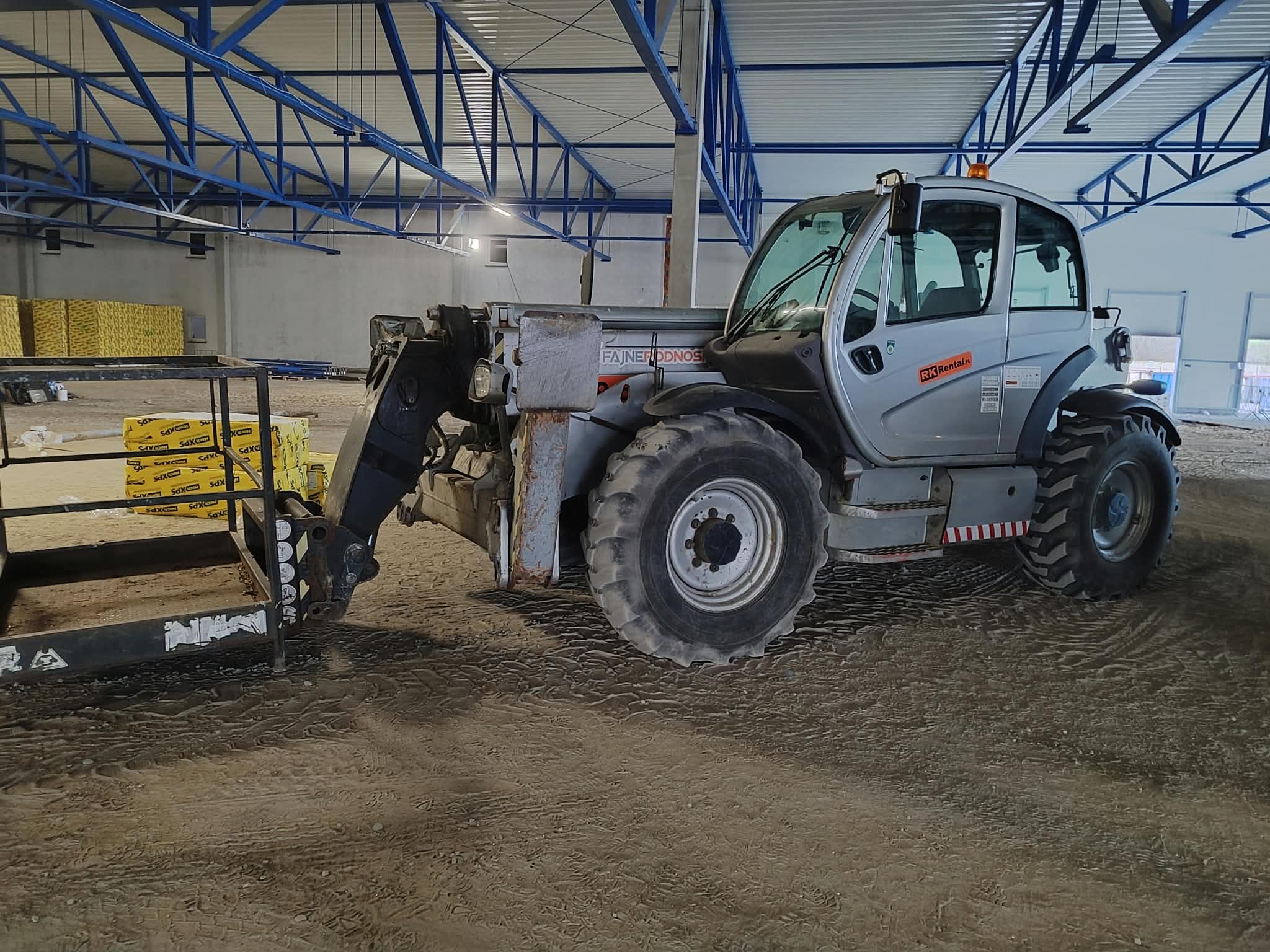 Ładowarka teleskopowa Manitou RK Rental podczas prac wewnątrz hali