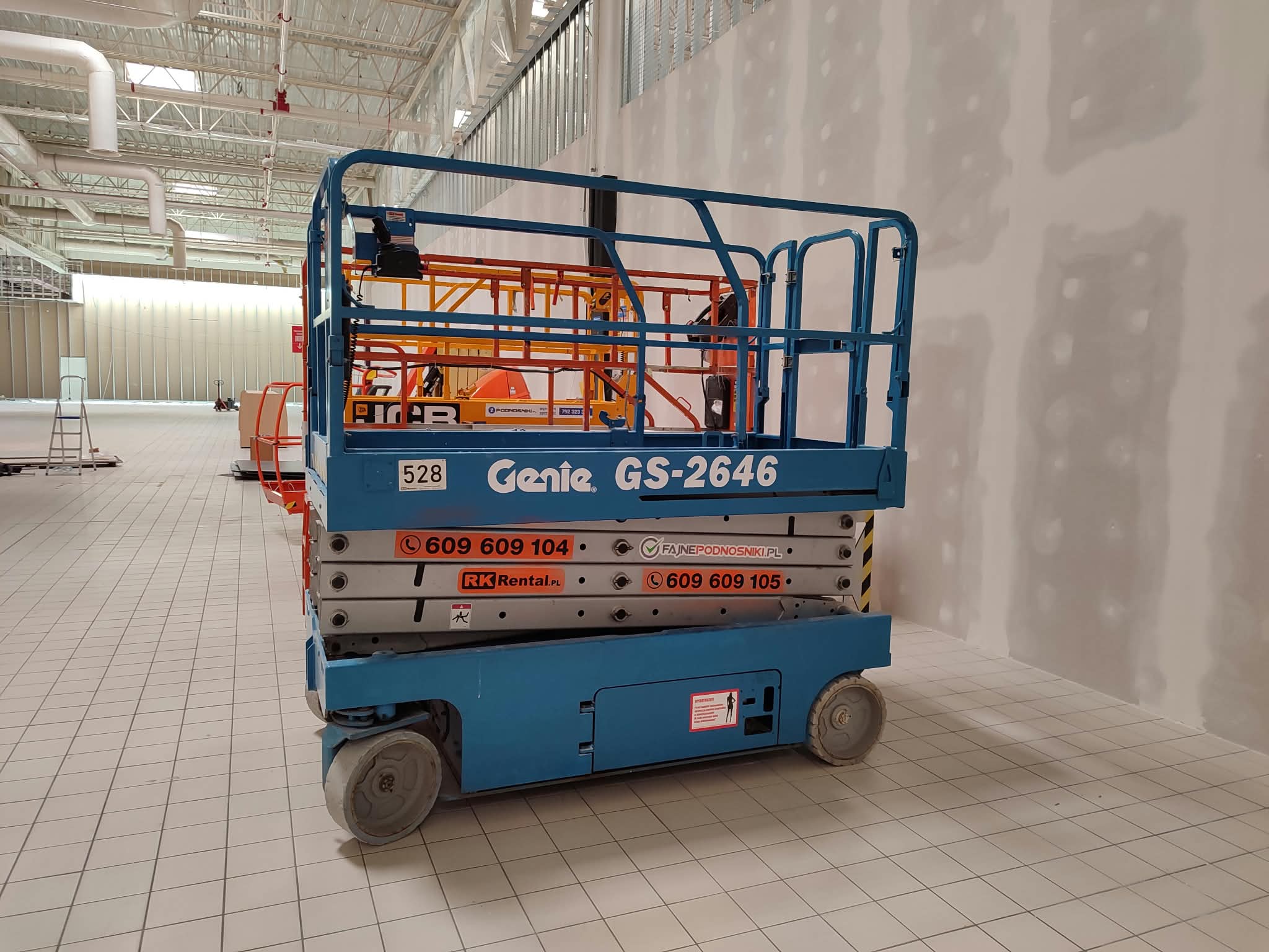Podnośnik nożycowy elektryczny Genie GS-2646 (10 m) RK Rental na budowie sklepu Biedronka w Złotowie — prace wykończeniowe w hali sprzedaży