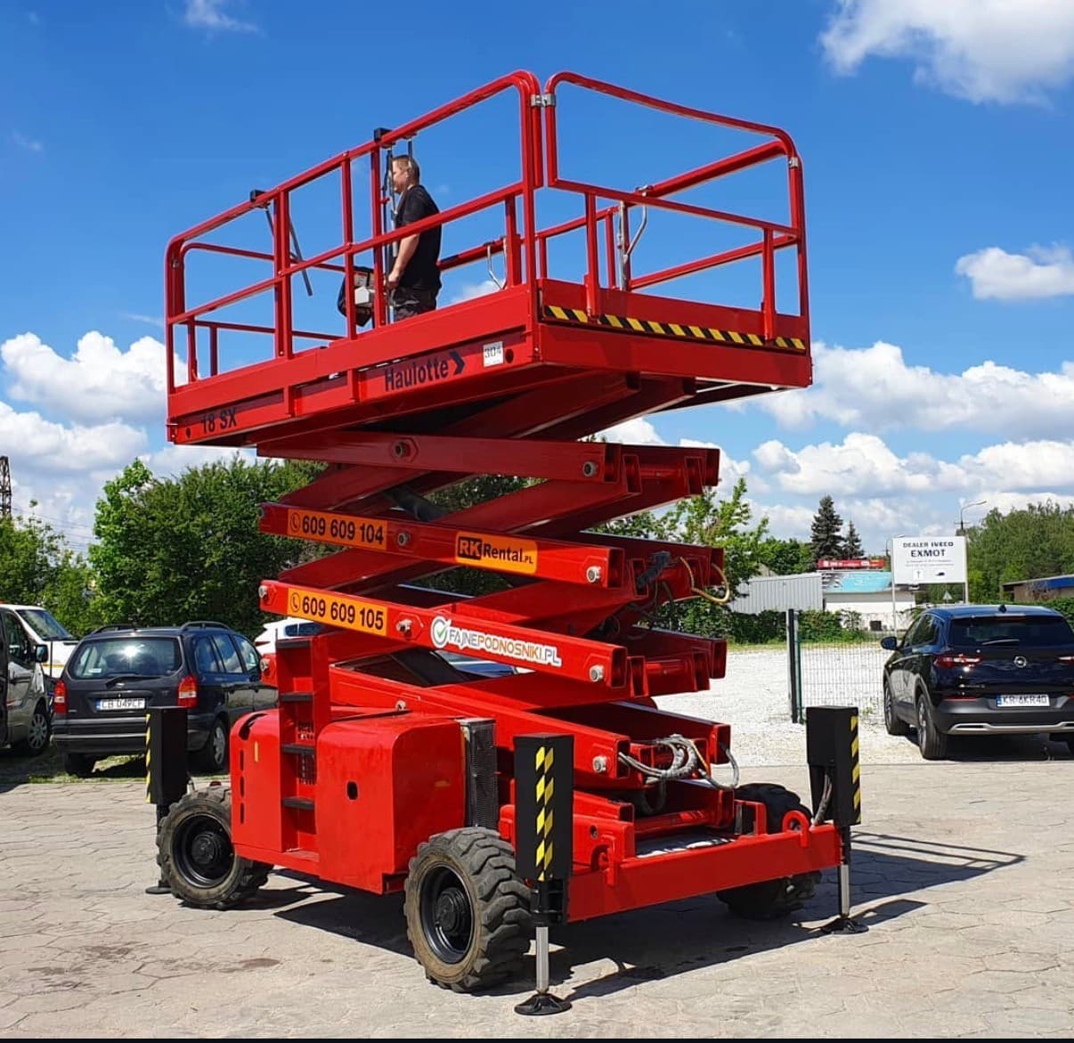 Terenowy podnośnik nożycowy Haulotte H18SX 4x4 RK Rental z podniesioną platformą podczas kontroli na placu w Brzozie przed dostawą do klienta w Kole