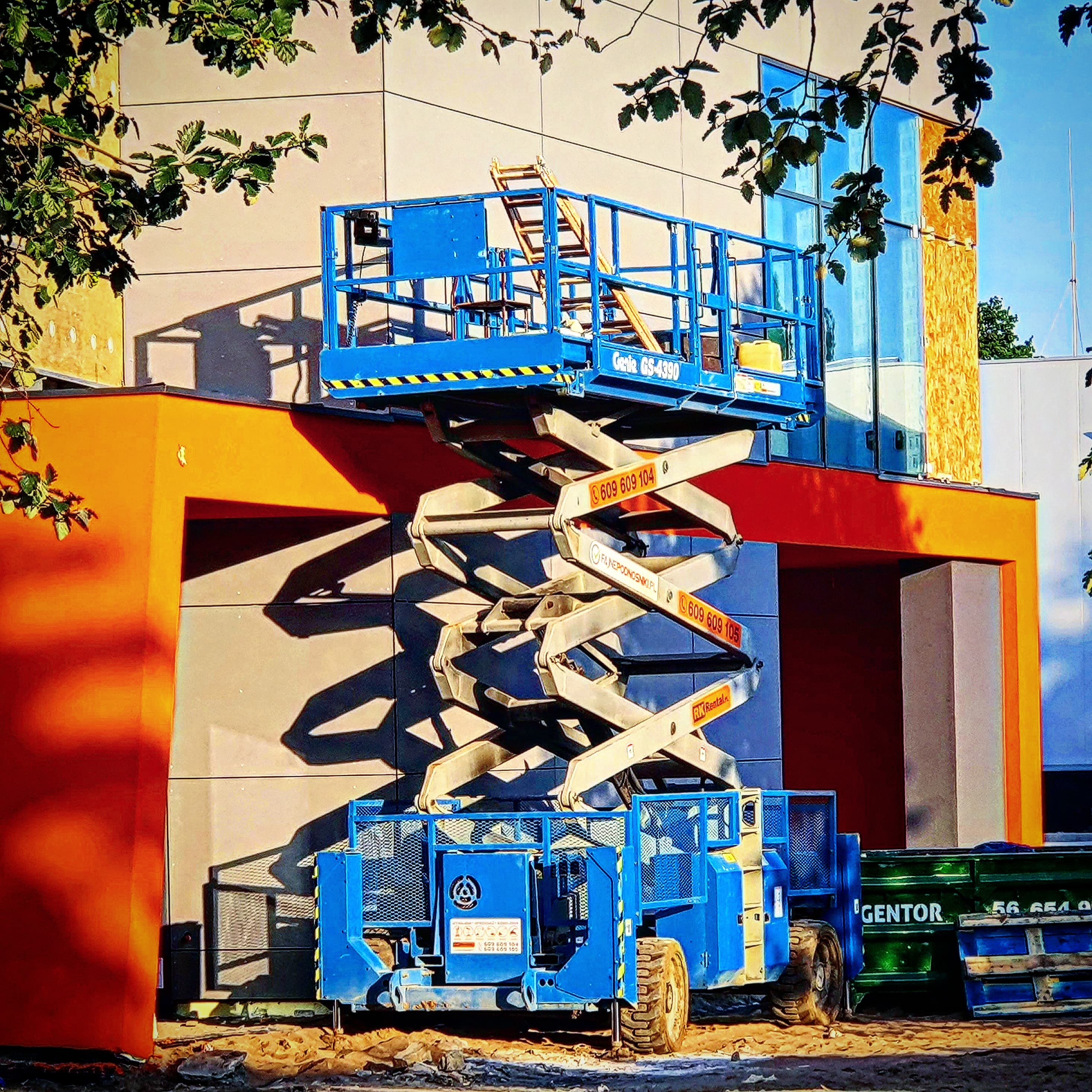 Genie GS-4390 rough terrain scissor lift (15 m) from RK Rental during work on a colourful façade in Kalisz